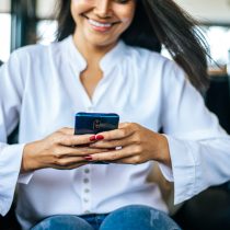 woman wearing white clothes and sitting play smartphone